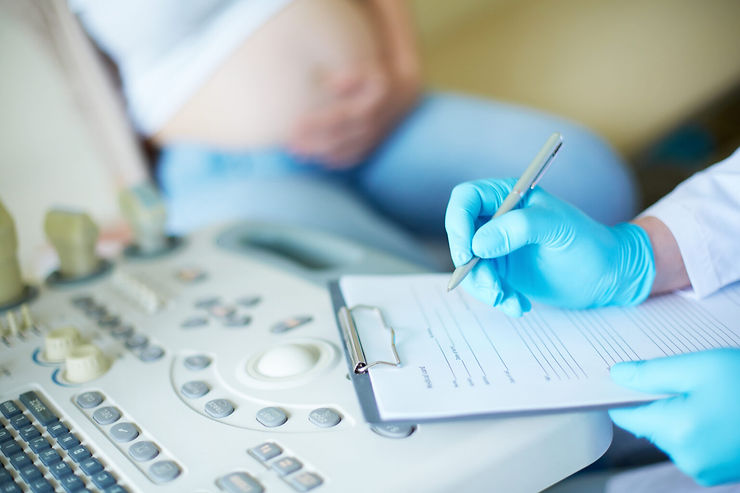 Doctor taking notes of patient questions at Feto Maternal & GenetYX Center