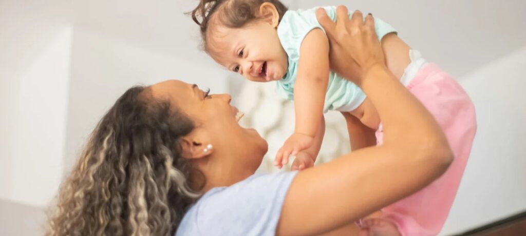 Happy down syndrome baby with loving mother, enjoying a joyful moment together.