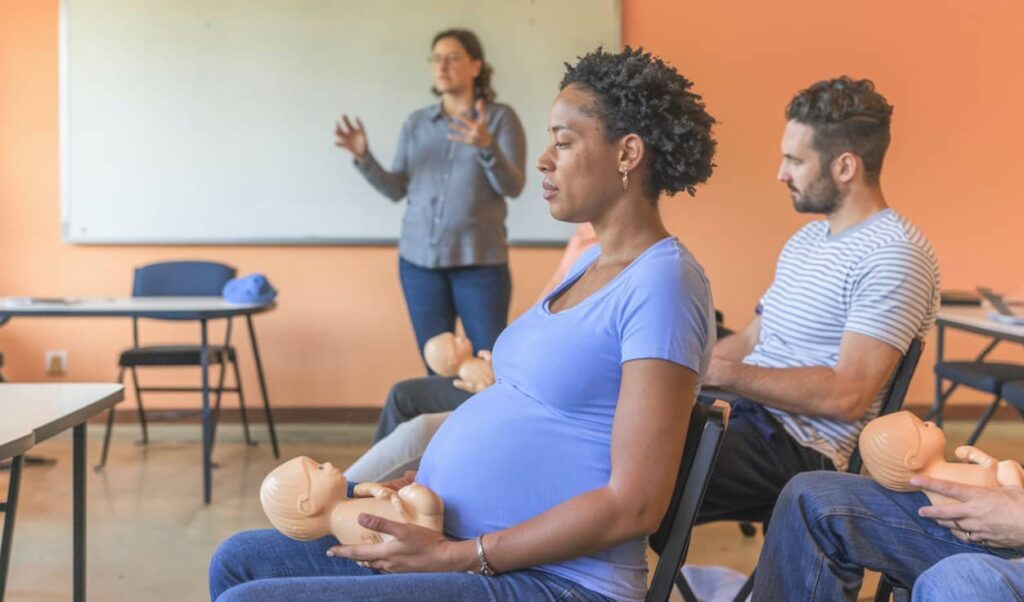 A pregnant woman attending a childbirth class with a birthing partner.